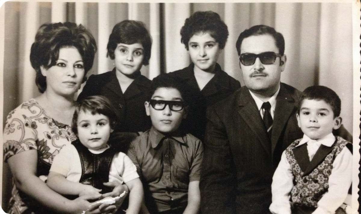 A vintage black and white  photo of dad's family of seven before they fled to kuwait. 